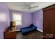 Cozy bedroom featuring a blue daybed, purple walls, hardwood floors, and a bright window at 7016 Tirzah Rd, Waxhaw, NC 28173