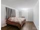 Neutral bedroom with hardwood floors, bright window, decorative quilt, and built-in shelves at 7016 Tirzah Rd, Waxhaw, NC 28173