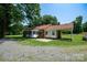 Rear exterior of house with covered carport, gravel parking and small brick shed at 7016 Tirzah Rd, Waxhaw, NC 28173