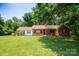 Charming red brick home with a spacious front yard, mature trees, and covered entrance at 7016 Tirzah Rd, Waxhaw, NC 28173