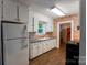 Kitchen featuring white cabinets, brick accent wall, and hardwood floors at 7016 Tirzah Rd, Waxhaw, NC 28173