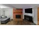 Comfortable living room featuring brick fireplace, tv, and hardwood flooring at 7016 Tirzah Rd, Waxhaw, NC 28173