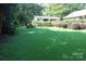 Lush backyard view with mature trees and green grass, ideal for outdoor activities and relaxation at 7017 Knightswood Dr, Charlotte, NC 28226