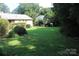 Large backyard with lush green grass and mature landscaping, offering a private outdoor retreat at 7017 Knightswood Dr, Charlotte, NC 28226