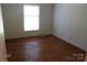Standard bedroom with hardwood floors, window with blind, and a neutral wall color at 7017 Knightswood Dr, Charlotte, NC 28226