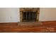 Living room fireplace with brick surround and hearth, complemented by hardwood floors at 7017 Knightswood Dr, Charlotte, NC 28226