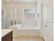 Bright bathroom featuring a large bathtub and a glass-enclosed shower for a spa-like experience at 8036 Crater Lake Dr, Fort Mill, SC 29707