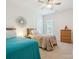 Bright bedroom featuring twin beds, neutral walls and carpet, ceiling fan, and a decorative accent mirror at 8036 Crater Lake Dr, Fort Mill, SC 29707