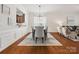 Bright dining area featuring hardwood floors and wainscoting, with a view into the living room and kitchen at 8036 Crater Lake Dr, Fort Mill, SC 29707