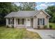 Charming one-story home featuring black shutters, a welcoming front porch and manicured landscaping at 903 Brookdale St, Kannapolis, NC 28083