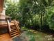Spacious backyard with a wooden deck and steps leading to lush green lawn, perfect for outdoor enjoyment at 9415 Braemar Ter, Charlotte, NC 28210