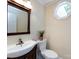 Bathroom with oak vanity, a patterned mirror, and a corner window with natural light at 9415 Braemar Ter, Charlotte, NC 28210