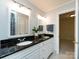 Bright bathroom with double sinks, granite counters, and a separate door to another room at 9415 Braemar Ter, Charlotte, NC 28210