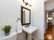 Well-lit bathroom features a pedestal sink and decorative mirror at 9415 Braemar Ter, Charlotte, NC 28210