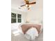 Bedroom featuring two windows providing natural light, white walls, and a ceiling fan at 9415 Braemar Ter, Charlotte, NC 28210