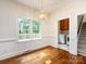 This dining area has natural light and hardwood floors next to the laundry room and stairs at 9415 Braemar Ter, Charlotte, NC 28210