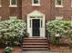 Close up view of the brick home's front door and manicured landscaping at 9415 Braemar Ter, Charlotte, NC 28210