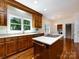 Classic kitchen with island cooktop, wood cabinetry and stainless steel dishwasher at 9415 Braemar Ter, Charlotte, NC 28210
