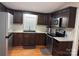 A kitchen with dark wood cabinets and stainless steel appliances at 110 Indian Harbor Cir, Mount Gilead, NC 27306