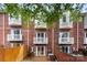 Brick townhome featuring small patios with white railings and a privacy fence at 1125 Kurt Ct, Charlotte, NC 28209