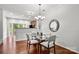 Dining area featuring hardwood floors, modern lighting, and a glass top dining table at 1125 Kurt Ct, Charlotte, NC 28209