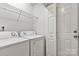 A laundry room with a washer and dryer next to a door with a wire rack above at 1125 Kurt Ct, Charlotte, NC 28209