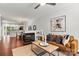 Cozy living room with fireplace, hardwood flooring, ceiling fan, and open to the dining area at 1125 Kurt Ct, Charlotte, NC 28209