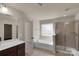 Bright bathroom with a soaking tub, shower, vanity, and access to bedroom at 11538 Ardrey Crest Dr, Charlotte, NC 28277