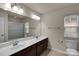 A spacious bathroom featuring a double vanity with a large mirror and tiled floor at 11538 Ardrey Crest Dr, Charlotte, NC 28277