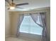 Bright bedroom featuring a ceiling fan and window with patterned curtains for ample natural light at 11538 Ardrey Crest Dr, Charlotte, NC 28277