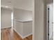 Hallway with wood flooring, white trim and neutral walls, door leading to bedroom and bathroom visible at 11538 Ardrey Crest Dr, Charlotte, NC 28277
