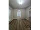Spacious living room with hardwood floors and an open entryway showcases neutral paint color and arched doorway at 11538 Ardrey Crest Dr, Charlotte, NC 28277