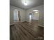 Living room featuring hardwood floors, arched doorways, and access to the staircase at 11538 Ardrey Crest Dr, Charlotte, NC 28277