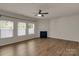 Bright living room features hardwood floors, a fireplace, a ceiling fan and three bright windows at 11538 Ardrey Crest Dr, Charlotte, NC 28277