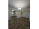 Open-concept living room features hardwood floors, decorative columns, and views of the staircase and nearby window at 11538 Ardrey Crest Dr, Charlotte, NC 28277