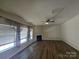 Living room features hard wood floors, neutral paint, many windows, a fan, and a fireplace at 11538 Ardrey Crest Dr, Charlotte, NC 28277