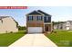 Two-story home featuring a two-car garage, brick accents, and a well-manicured lawn at 12020 Zazu Way, Charlotte, NC 28215