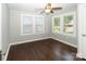 Bright bedroom with two windows, ceiling fan, hardwood floors, and neutral paint color at 1208 Martin Luther King Ave, Kannapolis, NC 28083