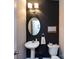Powder room with pedestal sink, commode, and framed art at 12928 Windy Lea Ln, Huntersville, NC 28078
