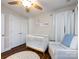 Cozy Bedroom featuring a white crib, comfortable armchair, and natural light streaming through the window at 12928 Windy Lea Ln, Huntersville, NC 28078