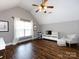 Versatile bonus room with hardwood floors, featuring a seating area and entertainment center for relaxation and enjoyment at 12928 Windy Lea Ln, Huntersville, NC 28078