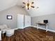 Well-lit bonus room with wood floors, featuring a comfortable seating area and a convenient workspace at 12928 Windy Lea Ln, Huntersville, NC 28078