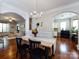 Open dining room with hardwood floors and archway leading to the kitchen and living room at 12928 Windy Lea Ln, Huntersville, NC 28078