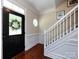Bright entryway featuring hardwood floors, staircase with white railing, and detailed trim work at 12928 Windy Lea Ln, Huntersville, NC 28078