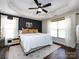Spacious bedroom with a dark accent wall, complemented by a large window, plush bed, and hardwood floors at 12928 Windy Lea Ln, Huntersville, NC 28078