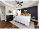 Large bedroom with dark accent wall, hardwood floors, and natural light creating a serene and inviting atmosphere at 12928 Windy Lea Ln, Huntersville, NC 28078