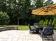 Outdoor patio area with stone pavers, seating area, and landscaping, ideal for relaxation and entertainment at 12928 Windy Lea Ln, Huntersville, NC 28078