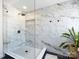 Elegant shower with marble tiling, rainfall showerhead, and built-in niche for a spa-like experience at 12928 Windy Lea Ln, Huntersville, NC 28078