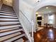 View from the staircase looking towards a living room with hardwood floors and a fireplace at 12928 Windy Lea Ln, Huntersville, NC 28078