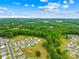Aerial view of a community with lush green trees, showcasing neighborhood layout and serene surroundings at 132 Sycamore Crossing Ct, Locust, NC 28097
